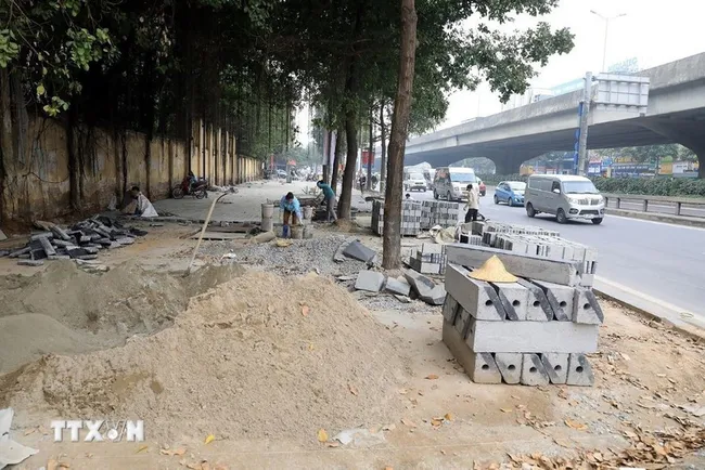 A section of the sidewalk is under construction. (Photo: VNA)