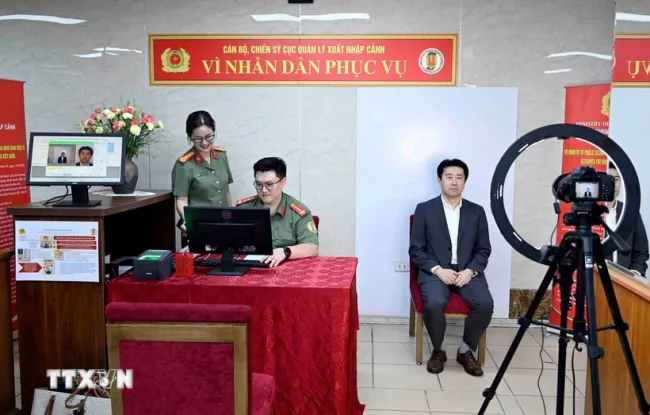 Immigration officers conduct the procedures to issue level-2 electronic identification accounts for a foreigner (Photo: VNA)