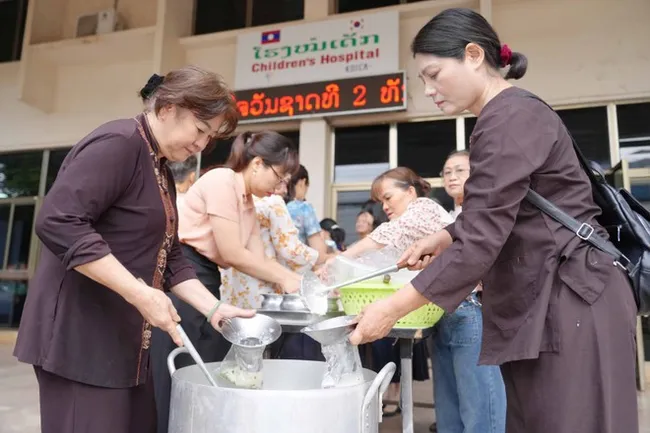 OVs in Laos are preparing meals for patients and disadvantaged people. (Photo: VNA)