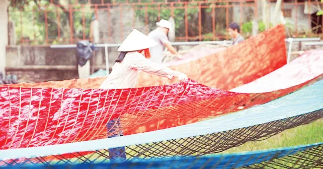 Nha Xa villagers dry silk.