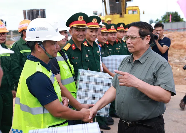 Prime Minister Pham Minh Chinh (R) meets with the units constructing Terminal 2 of Dong Hoi Airport (Photo: VNA)