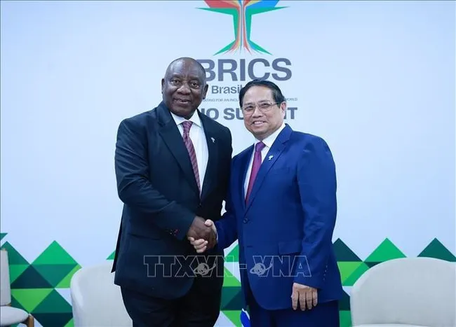 Prime Minister Pham Minh Chinh (R) shakes hands with South African President Cyril Ramaphosa at their meeting in Rio de Janeiro, Brazil, on July 6. (Photo: VNA)