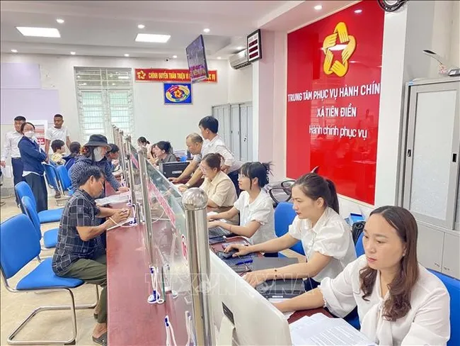 Civil servants and citizens carry out administrative procedures at the public administrative service centre of Tien Dien commune, Ha Tinh province. (Photo: VNA)