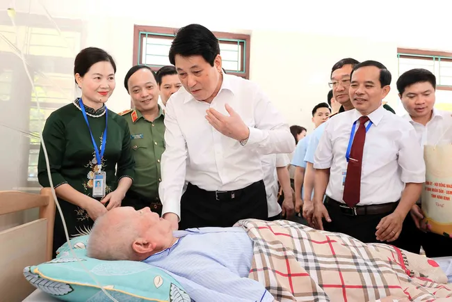 State President Luong Cuong visits and presents gifts to wounded soldier Nguyen Xuan Mai, who is receiving treatment at the Duy Tien War Invalids Nursing Centre. (Photo: VNA)