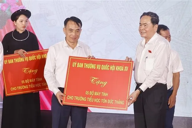 National Assembly Chairman Tran Thanh Man (R) presents 15 computer sets to Ton Duc Thang, Tan Trao, and Kim Quan Primary Schools in Tan Trao commune. (Photo: VNA)