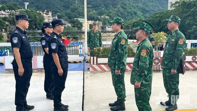 Before the patrol, the Lao Cai and Chinese commands met at the demarcation line at the Lao Cai international border gate to exchange information. (Photo: qdnd.vn)