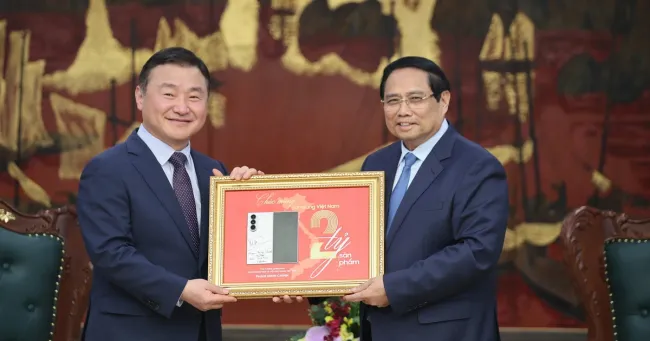 Prime Minister Pham Minh Chinh (R) and acting head of Samsung Electronics' Device Experience Division Roh Tae Moon. (Photo: VNA)