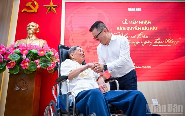 Musician Pham Tuyen and Editor-in-Chief of Nhan Dan Newspaper Le Quoc Minh at the hand-over ceremony. (Photo: THANH DAT)