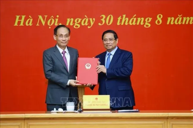 Prime Minister Pham Minh Chinh hands over the decision to assign Le Hoai Trung, Secretary of the Party Central Committee and Chief of the Party Central Committee Office, as Acting Minister of Foreign Affairs in Ha Noi on August 30. (Photo: VNA)