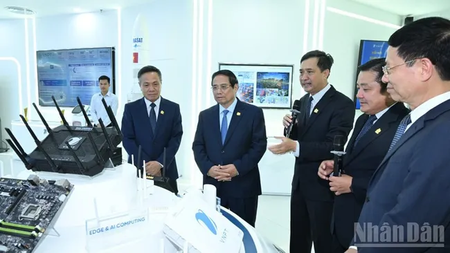 Prime Minister Pham Minh Chinh listens to the leaders of VNPT introduce new technology equipment. (Photo: TRAN HAI).