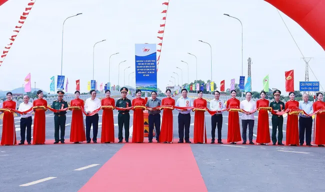 Prime Minister Pham Minh Chinh and delegates perform the ribbon-cutting ceremony to inaugurate the new Phong Chau bridge on National Highway 32C. (Photo: VNA)