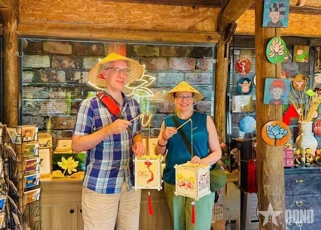 Foreign tourists experience making lanterns at the Van Mieu – Quoc Tu Giam complex in Hanoi. (Photo: qdnd.vn)