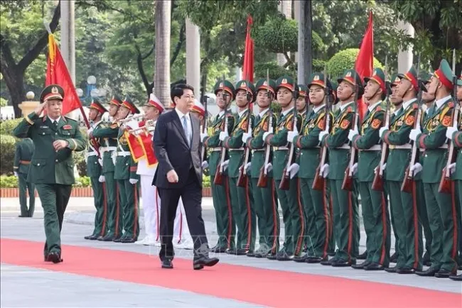 State President Luong Cuong inspects the guard of honour at the National Defence Academy (Photo: VNA)