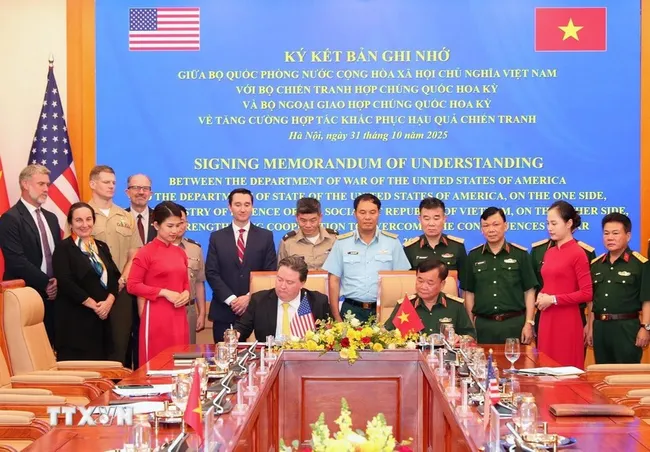 Deputy Minister of National Defence Senior Lieutenant General Hoang Xuan Chien and US Ambassador to Vietnam Marc Knapper sign the memorandum of understanding on enhancing cooperation in addressing the legacies of war in Hanoi on October 31. (Photo: VNA)