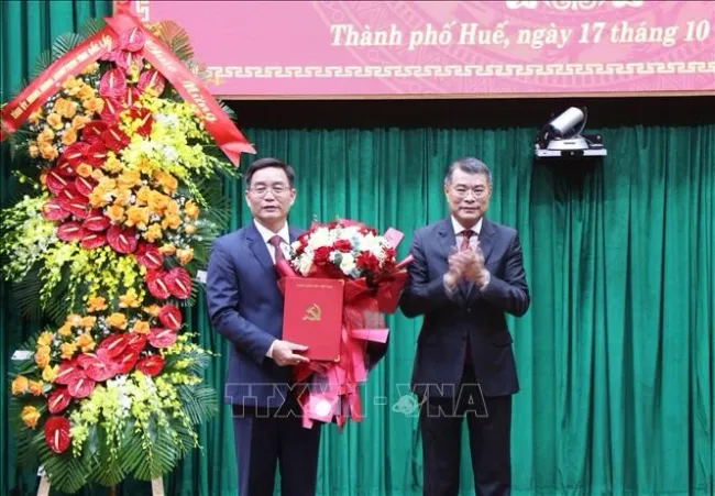 Politburo member, Secretary of the Party Central Committee, and Chairman of its Organisation Commission Le Minh Hung (R) hands overs the decision to Nguyen Dinh Trung at a ceremony on October 17, 2025 (Photo: VNA)