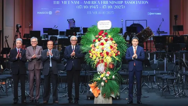 VUFO President Phan Anh Son (rightmost) presents flowers to congratulate the Viet Nam-USA Society on its founding anniversary. (Photo: Manh Nguyen)