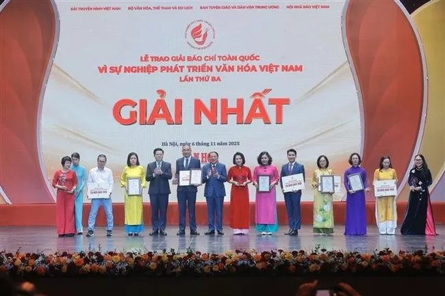 Deputy Prime Minister Mai Van Chinh and Minister of Culture, Sports and Tourism Nguyen Van Hung present first prizes to the winners. (Photo: VNA)