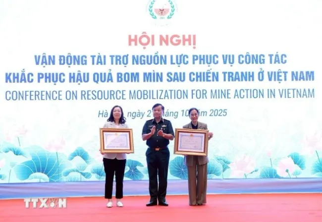 Sen. Lieut. Gen Hoang Xuan Chien, Deputy Minister of National Defence, presents Friendship Orders from the Vietnamese State President to the Korea International Cooperation Agency (KOICA) in Viet Nam and the PeaceTrees Viet Nam (PTVN). (Photo: VNA)