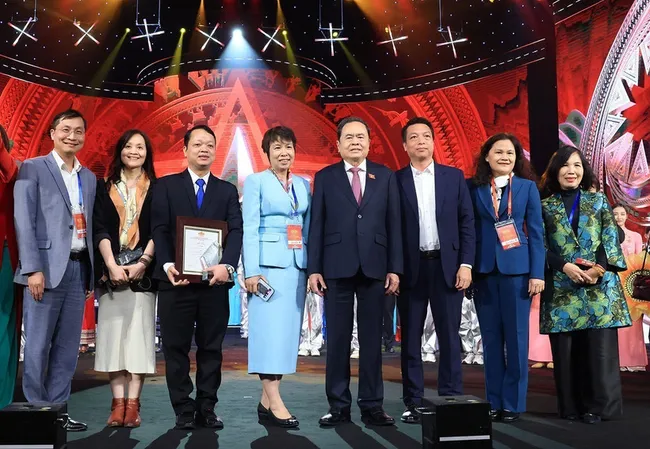 NA Chairman Tran Thanh Man (fourth, right) poses for a photo with VNA leaders and award-winning authors. (Photo: VNA