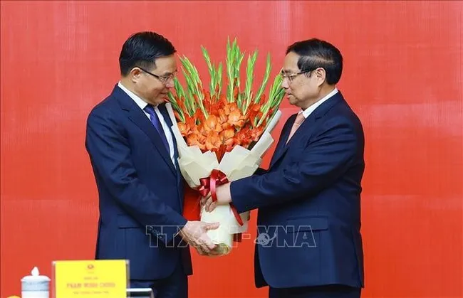 PM Pham Minh Chinh presents congratulatory flowers to Acting Minister of Industry and Trade Le Manh Hung. (Photo: VNA)
