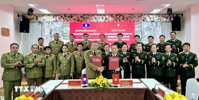 The Quang Tri Border Guard Command and the police of Laos' Salavan province sign the minutes of their annual talks on December 26. (Photo: released by VNA)
