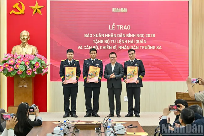 Editor in Chief of Nhan Dan Newspaper Le Quoc Minh presents Tet newspapers to representatives of the recipients. (Photo: NDO)