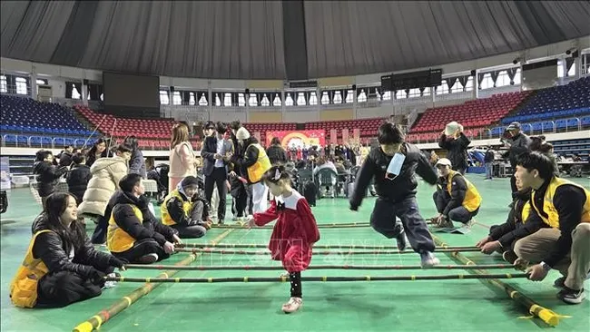 Mua sap (bamboo dancing), a traditional Vietnamese folk game, attracts many children from multicultural families to take part. (Photo: VNA)