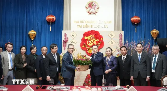 Vietnamese Ambassador Dang Minh Khoi and Lao Ambassador Shiphandone Oybuabuddy with officials and staff of the two embassies. (Photo: VNA)