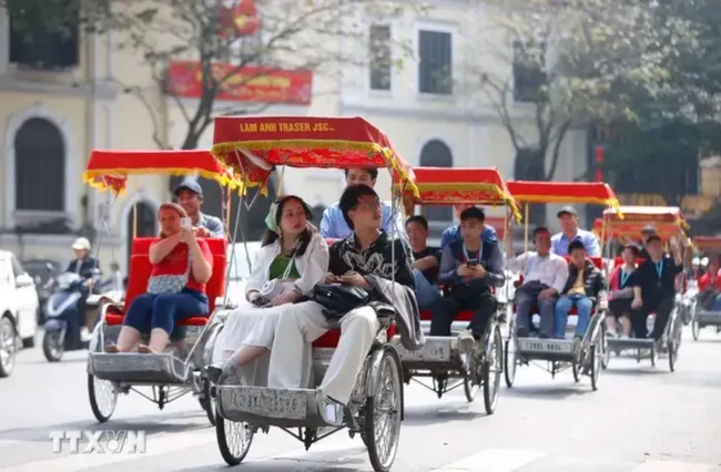 International tourists take a cyclo tour around Hoan Kiem Lake in Hanoi. (Photo: VNA)
