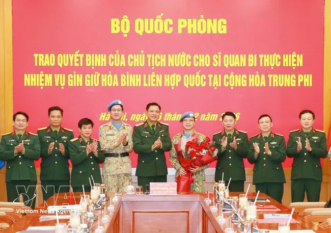 Officials at the ceremony presenting the decisions to Lieutenant Colonel Nguyen Hoang Long (fourth from right), who will serve at the UN Multidimensional Integrated Stabilisation Mission in the Central African Republic (MINUSCA) (Photo: VNA)