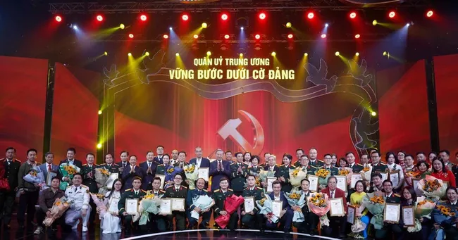 Party General Secretary To Lam and Minister of National Defence General Phan Van Giang pose for a photo with the award-winning authors and author groups. (Photo: VNA)