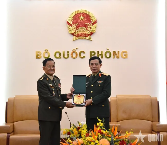 Minister of National Defence Gen. Phan Van Giang (R) hands over a gift to Secretary of State at the Cambodian Ministry of National Defence Gen. Prum Din at their meeting in Hanoi on March 9 (Photo: qdnd.vn)