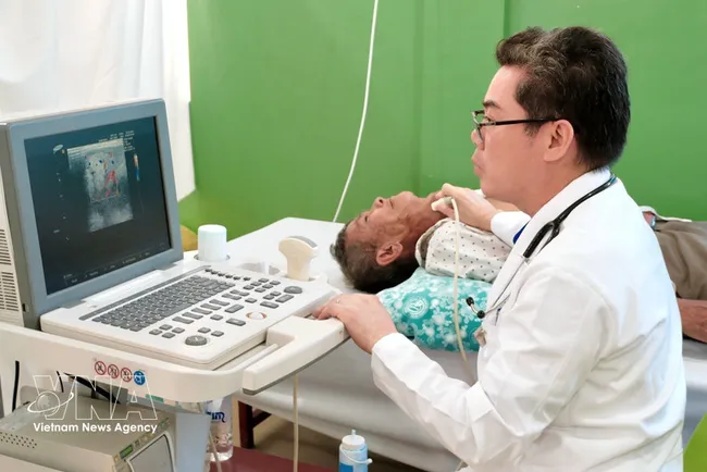 Dr Ton Thanh Tra, Director of Cho Ray–Phnom Penh Hospital, personally examines and performs an ultrasound for a critically ill patient, who was later admitted for free surgery at the hospital. (Photo: VNA)