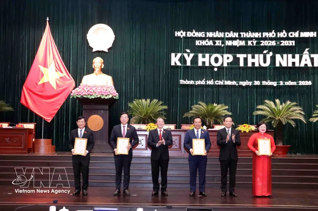 Politburo member and Secretary of the Ho Chi Minh City Party Committee Tran Luu Quang (second from right) and Vice Chairman of the National Assembly Nguyen Duc Hai (third from left) present certificates recognising members of the 11th-term Ho Chi Minh City People’s Council (2026–2031). (Photo: VNA)