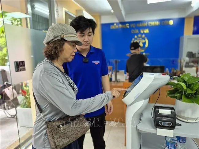 Citizens use an AI robot to assist with administrative procedures at Cua Nam ward in Hanoi. (Photo: VNA)