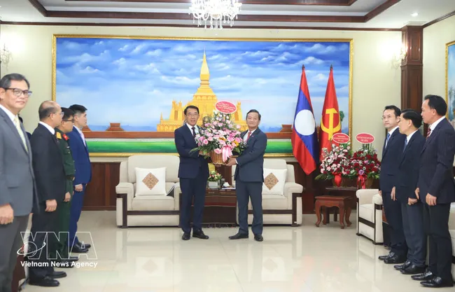 Ambassador Nguyen Minh Tam presents Party General Secretary To Lam's flowers to the LPRP Central Committee's External Relations Commission to congratulate on the LPRP's 71st founding anniversary. (Photo: VNA)