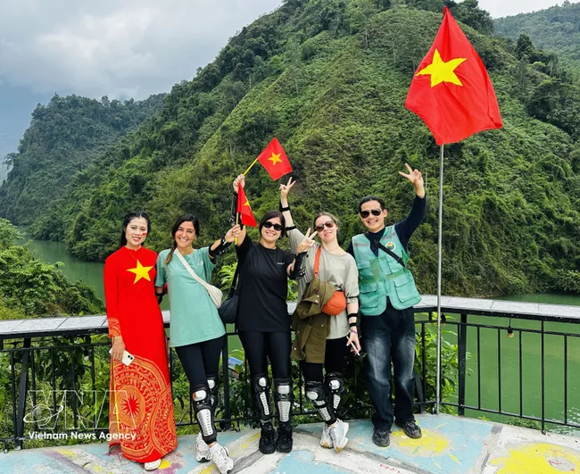 Foreign tourists in a photo with local residents. (Photo: VNA)