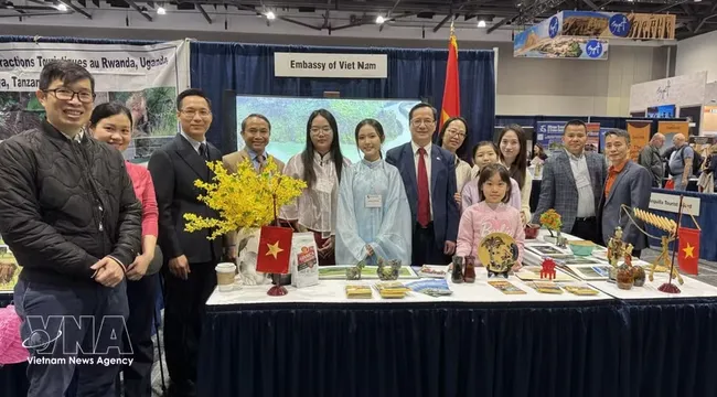 Ambassador Pham Vinh Quang (seventh from left) poses for a photo with staff of the Vietnamese Embassy in Canada at the Vietnam booth at the exhibition. (Photo: VNA)