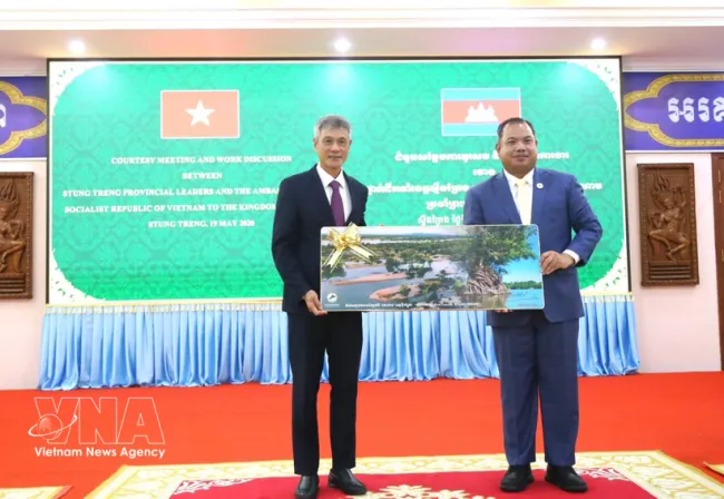Stung Treng Governor Sor Soputra (R) presents a souvenir to Ambassador Nguyen Minh Vu (Photo: VNA)