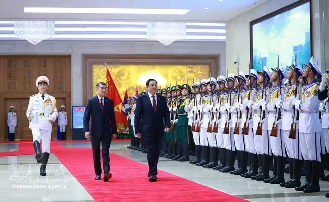 Prime Minister Le Minh Hung (left) and his Lao counterpart Sonexay Siphandone review the Guard of Honor of the Vietnam People's Army (Photo: VNA)