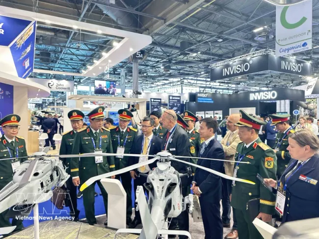 Deputy Defence Minister Senior Lieutenant General Nguyen Truong Thang and the Vietnamese delegation are briefed by a French partner on a combat helicopter model at Eurosatory 2026. (Photo: VNA)