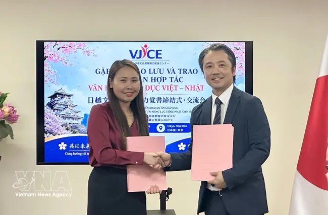 Representatives of the Vietnam – Japan Centre for Cultural and Educational Cooperation Promotion (VJCE) and the Aoyama School of Japanese exchange the signed agreement at the Vietnamese Embassy in Japan on July 3. (Photo: VNA)