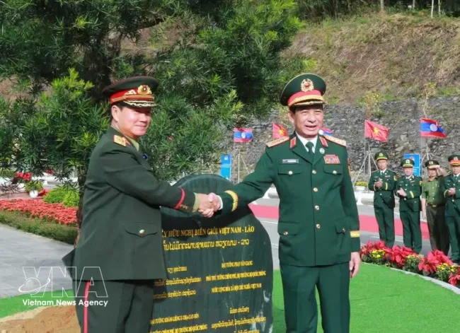 General Phan Van Giang (R) and General Khamlieng Outhakaysone plant a tree at Thanh Thuy border gate. (Illustrative photo: VNA)
