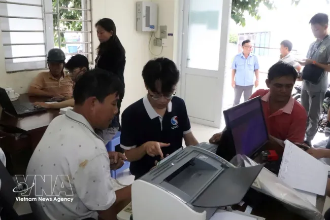 Staff from Viet Development Synergy Co. Ltd. guide fishermen in installing and using the electronic fishing logbook application. (Photo: VNA)