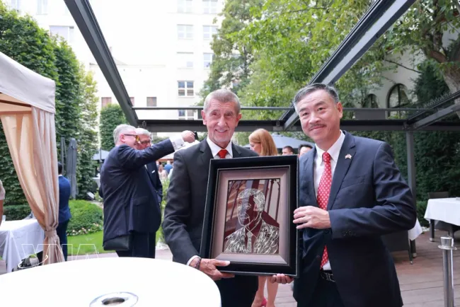 Vietnamese Ambassador to the Czech Republic Duong Hoai Nam (right) presents Prime Minister Andrej Babiš with an illustrated portrait of the Czech PM (Photo: VNA)