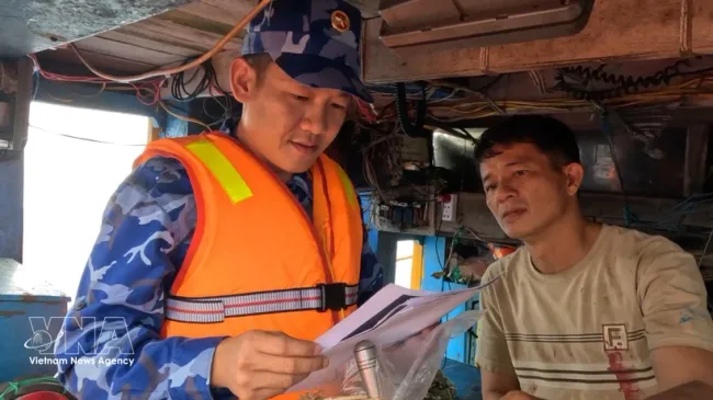 A working team from Coast Guard Region 2 Command inspects fishing licences and vessel monitoring system and guides fishermen on compliance with IUU fishing regulations. (Photo: VNA)
