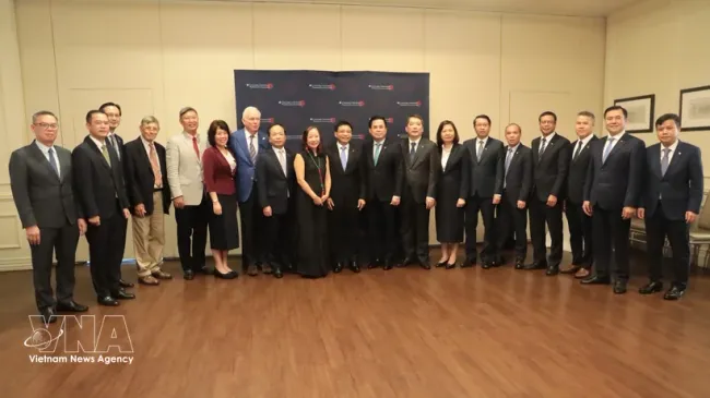 Deputy Prime Minister Nguyen Van Thang (centre) and the Vietnamese delegation pose for a photo with US professors. (Photo: VNA)