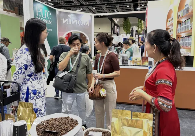 Malaysian customers sample Vietnamese coffee. (Photo: VNA)