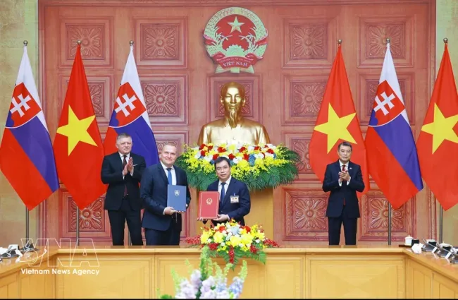 Prime Minister Le Minh Hung (first, right) and his Slovak counterpart Robert Fico (first, left) witness the signing of an MoU between the Commission for Standards, Metrology and Quality of Vietnam (STAMEQ) and the Office of Standards, Metrology and Testing (UNMS) of Slovakia in Hanoi on April 13, 2026. (Photo: VNA)