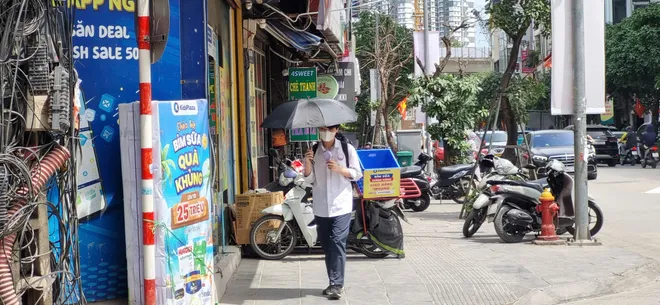 Hà Nội hầm hập nắng nóng đầu mùa, người dân "vật lộn" dưới nền nhiệt 37°C - Ảnh 4.